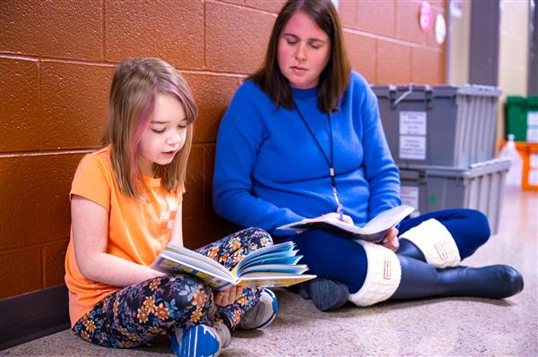 Volunteers reading with students. 